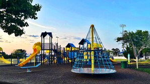 A playground with various play structures including slides and climbing areas.