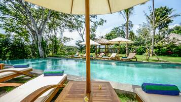 A poolside area with lounge chairs, a wooden deck, and a gazebo in the background.