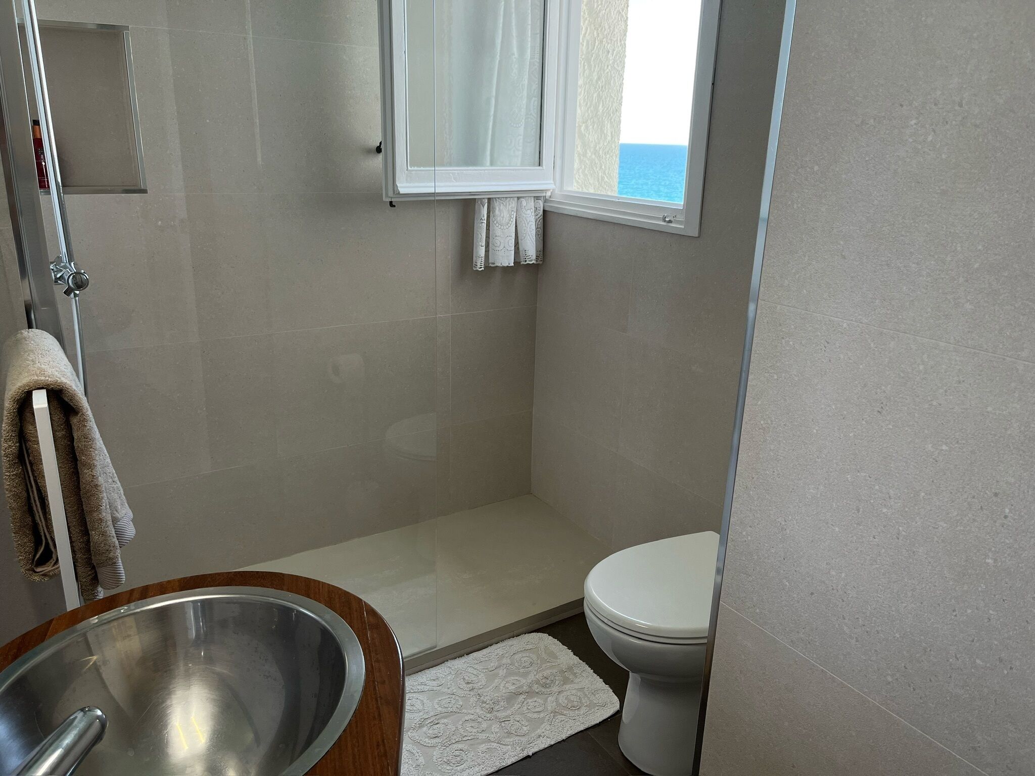 A bathroom with a shower, toilet, and sink.