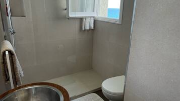 A bathroom with a shower, toilet, and sink.