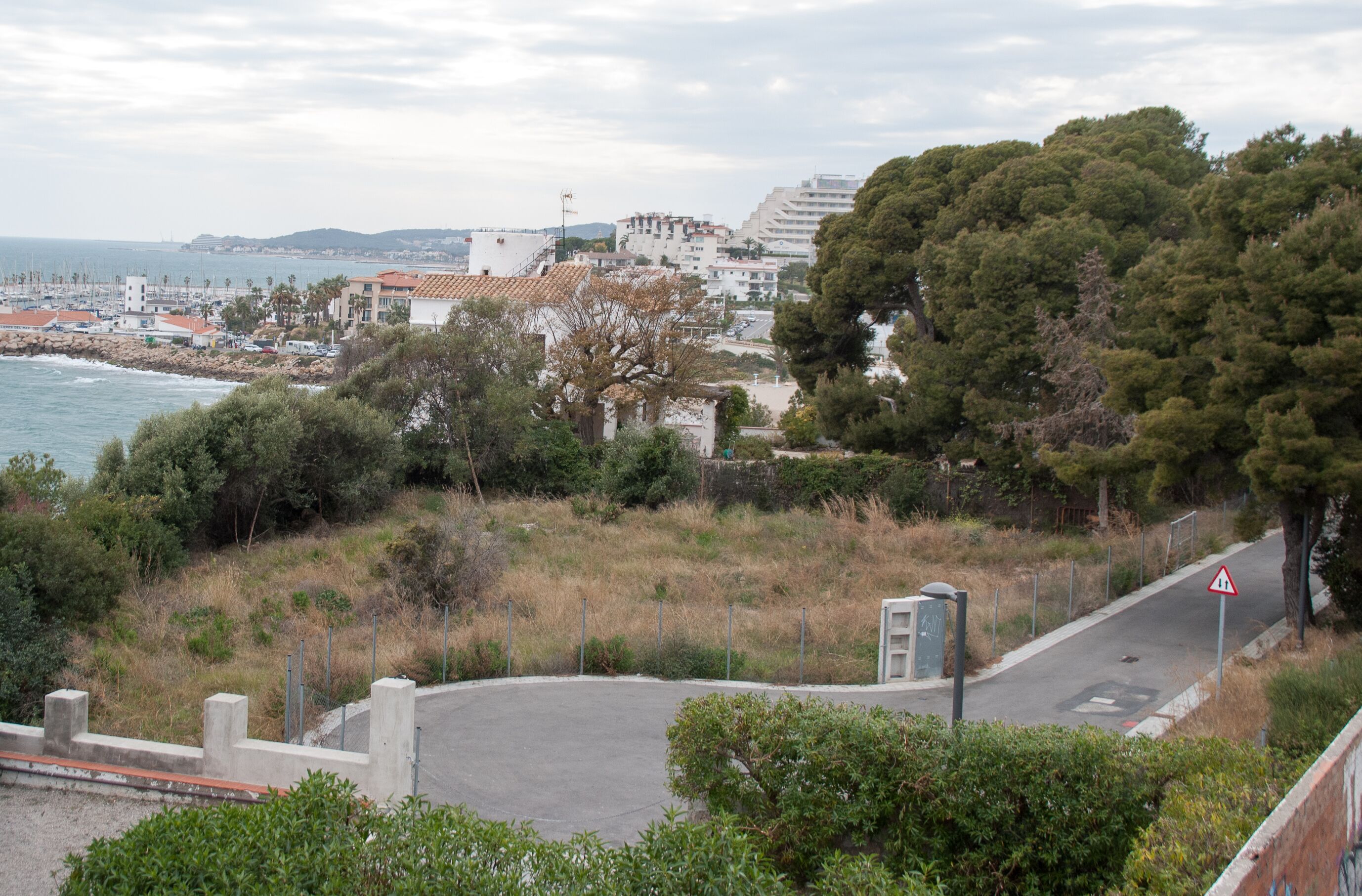 A coastal town with buildings, a road, and a beach.