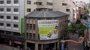 A multi-story building with a prominent sign advertising a breakfast service. - A Ace Hotel (Taichung)