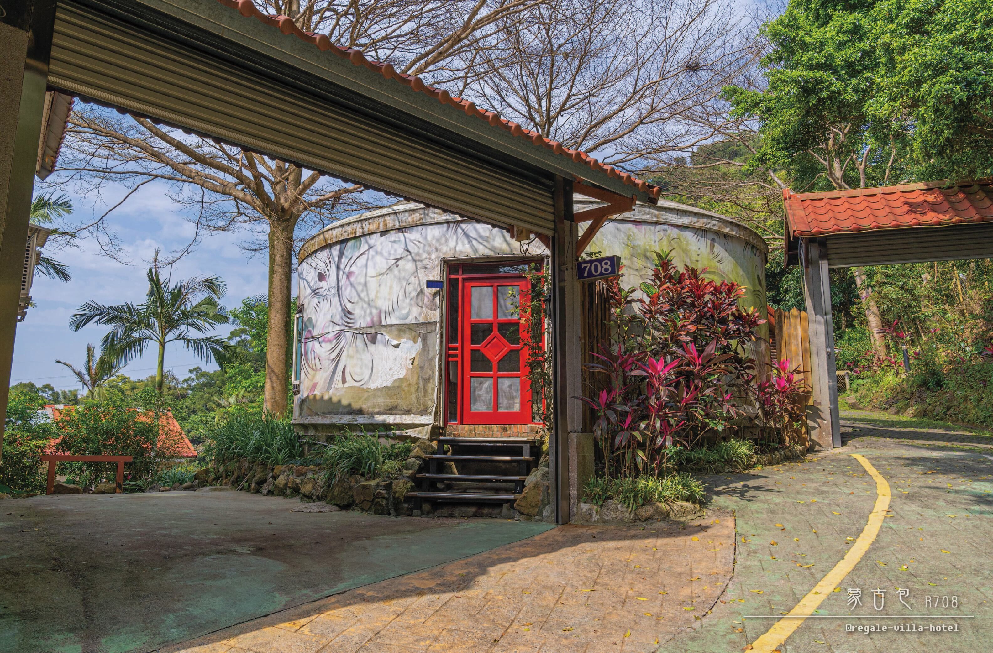 A building with a red door, a number 708 sign, and a covered walkway.