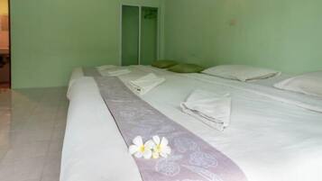 Une chambre d’hôtel avec un grand lit, une table de chevet et une lampe fixée au mur.