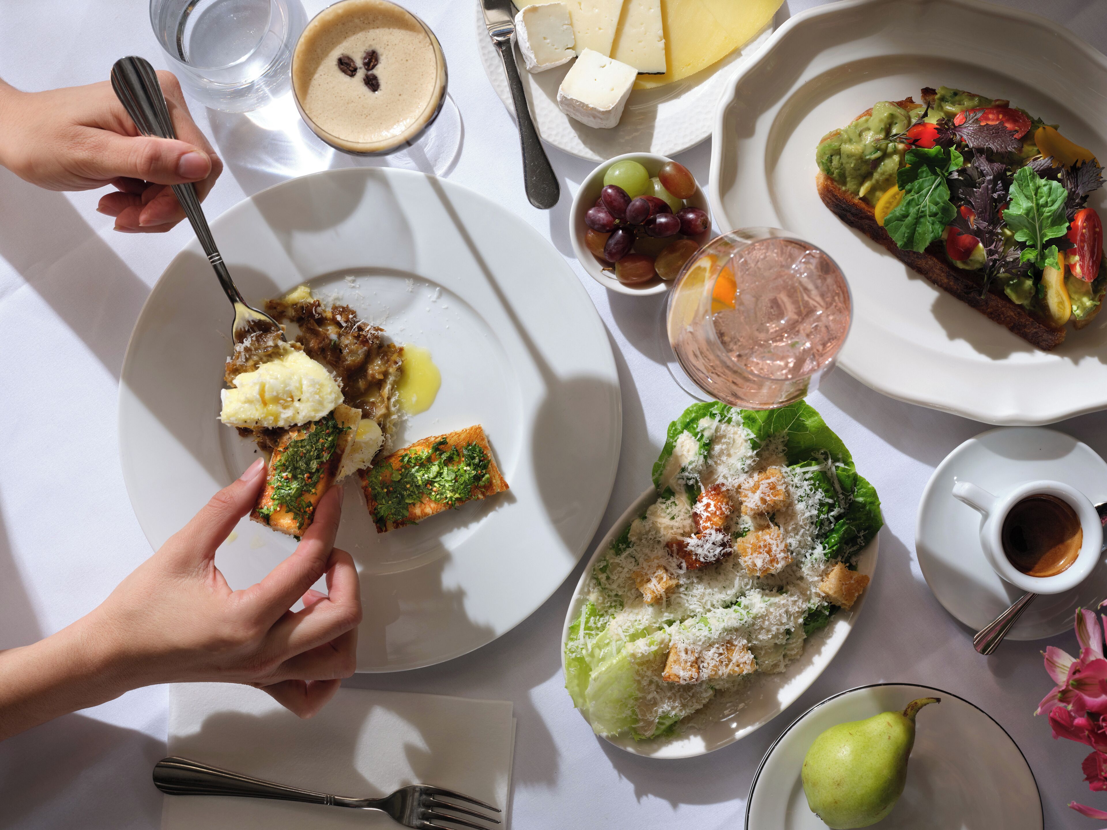 A table with various dishes including a salad, cheese, and a beverage.