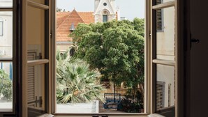 A window with an open view of a church and a tree. - The Drisco Hotel Tel Aviv - Relais & Châteaux (Tel Aviv)