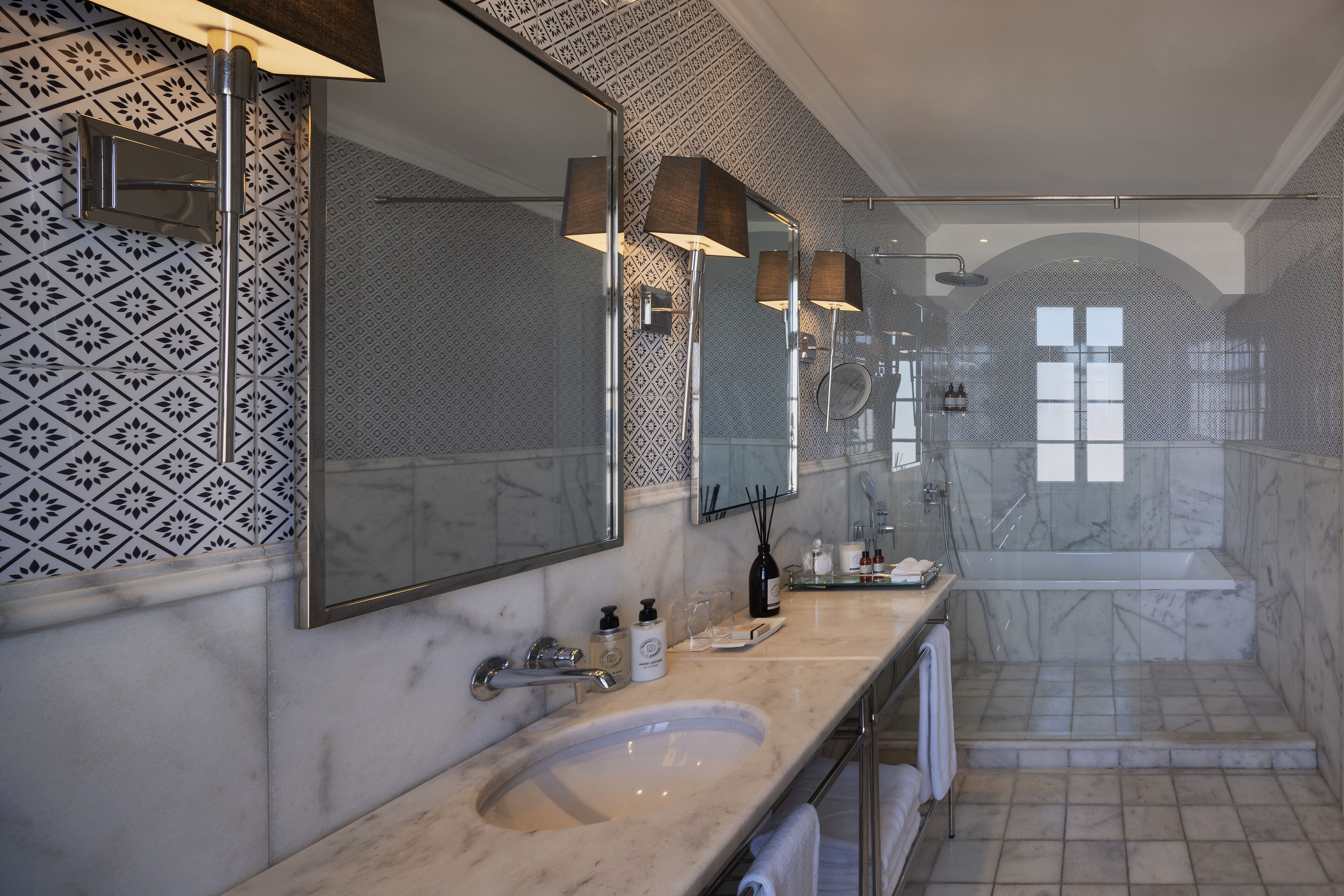 Ein modernes Badezimmer mit einem großen Waschbecken, mehreren Spiegeln und einer separaten Duschkabine.