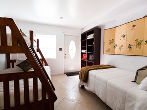 A bedroom with a wooden staircase, a bed, a wardrobe, and a door. - Bliss House (Hot Springs)