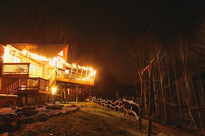 A wooden house with a balcony and a fence. - Private Mountain Retreat on 63 Acres | Waterfalls, Saunas | One Group at a Time (Hot Springs)