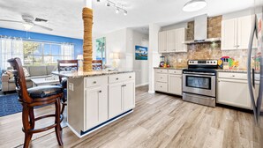A modern kitchen with white cabinets, a central island, and a built-in oven. - Minutes to Clearwater Beach, Indian Rocks Beach- Sleeps 10 w/Firepit & BBQ! (Largo)