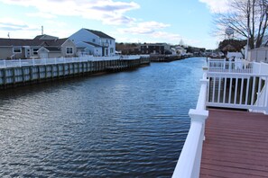 A waterfront property with a wooden deck and a white railing.