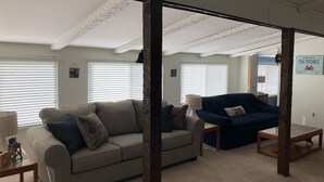Una sala de estar con dos sofás, una mesita de centro y una lámpara.