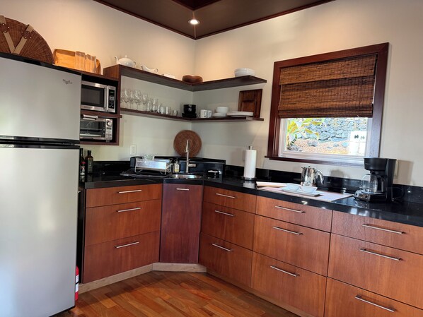 Una cocina moderna con armarios de madera, horno empotrado y ventana con vistas.