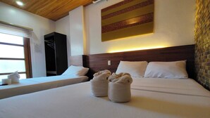 A hotel room with a large bed, two pillows, a headboard, a wall-mounted artwork, and a window with a view. - Taj Guesthouse Boracay (Boracay Island)