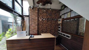 A reception desk with a sign that reads "Greshaus" and a wall with a brick pattern. - Taj Guesthouse Boracay (Boracay Island)