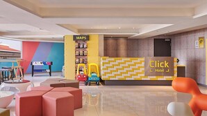 A hotel lobby with a reception desk, colorful seating, and a children's play area. - Click Hotel - Taipei Main Station Branch (Taipei)