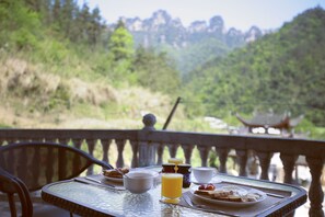 A breakfast table with a view of a mountainous landscape.