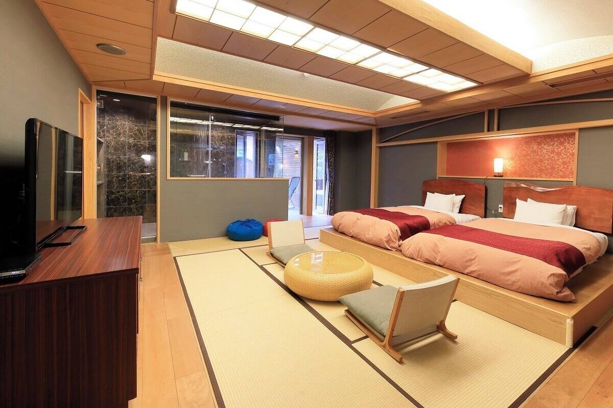 A modern hotel room with a large bed, a desk, and a television.