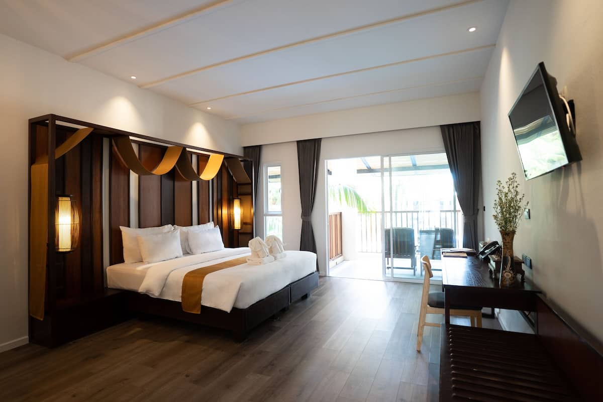 Une chambre d’hôtel moderne, dotée d’un grand lit, d’un bureau et d’une télévision.