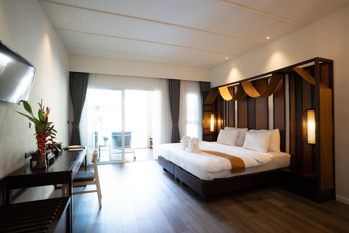 Une chambre d’hôtel moderne avec un grand lit, un bureau et une télévision.