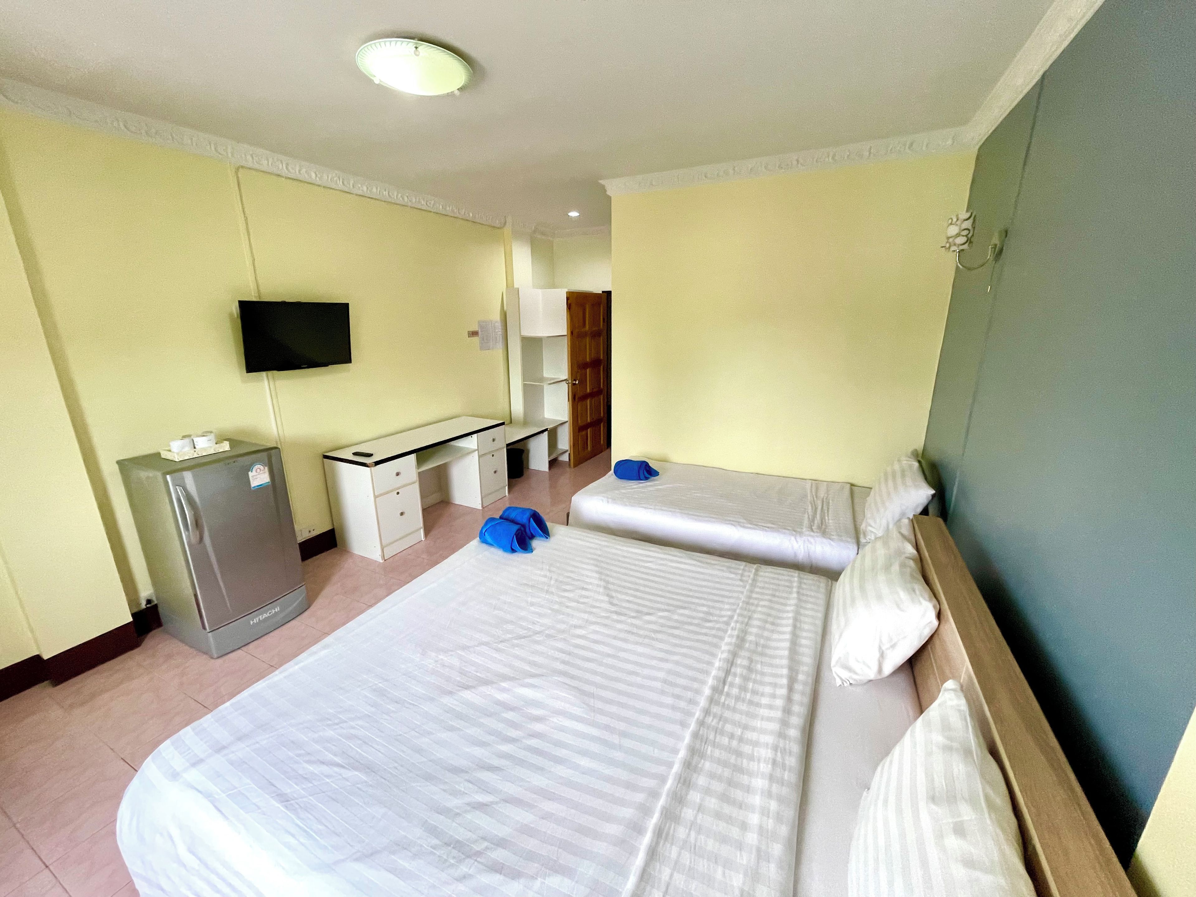 Una habitación de hotel con cama, escritorio, televisión y minibar.