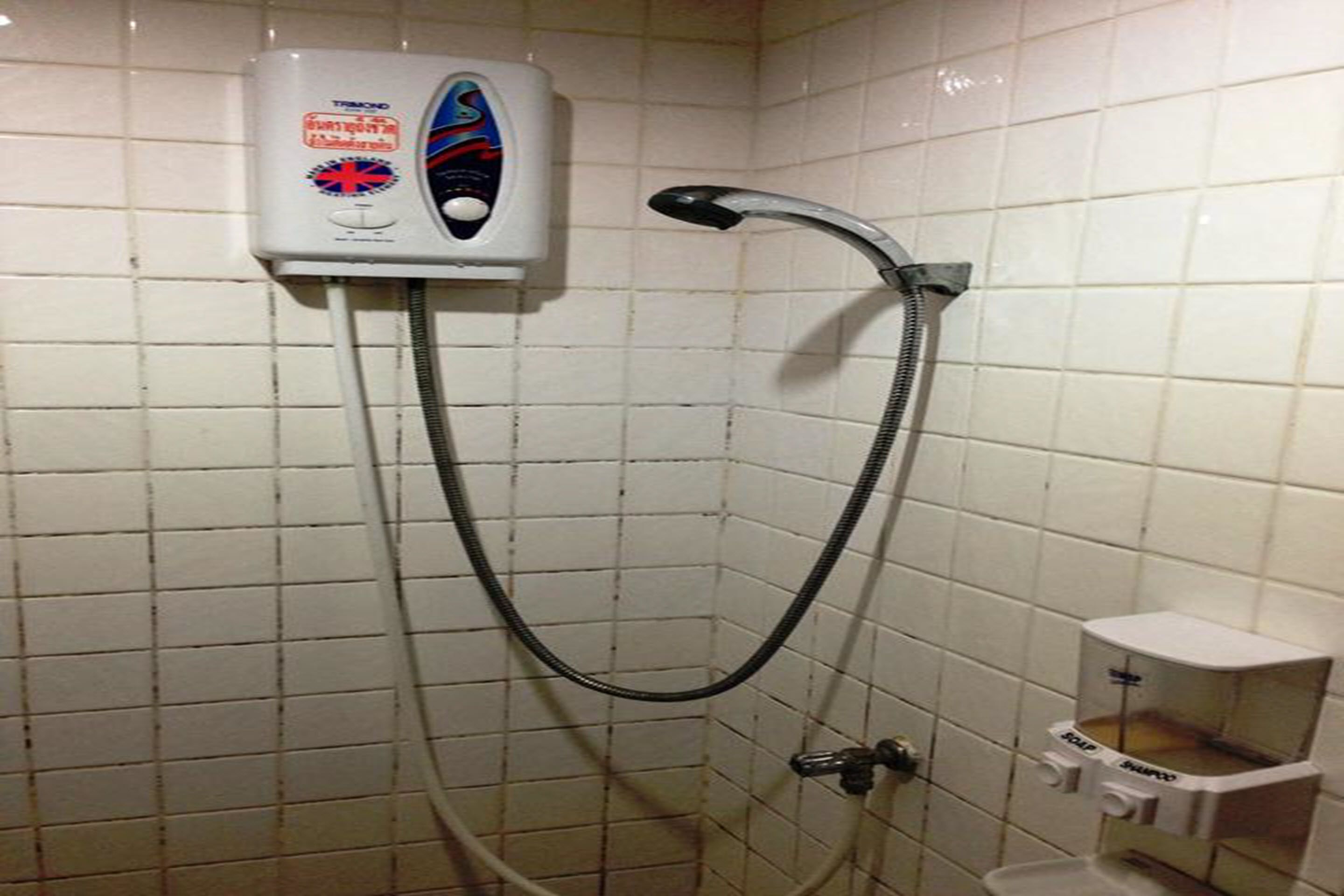 A shower with a handheld showerhead and a wall-mounted control panel.