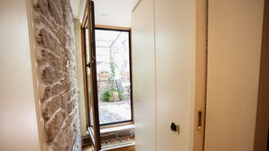 A narrow hallway with a stone wall on one side and a door on the other. - Vatican luxury home Terrazzo, 2 bedrooms 2 bathrooms a 50 yds from  S.Pietro (Roma)