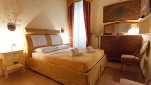 A neatly arranged bedroom with a large bed, a wooden dresser, a chair, and a mirror on the wall. - Vatican luxury home Terrazzo, 2 bedrooms 2 bathrooms a 50 yds from  S.Pietro (Roma)