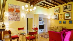 A dining area with a glass table and chairs, a red sofa, and a chandelier. - Vatican luxury home Terrazzo, 2 bedrooms 2 bathrooms a 50 yds from  S.Pietro (Roma)