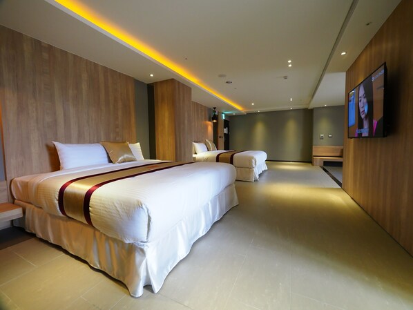 A modern hotel room with a large bed, a smaller bed, a sofa, and a TV on the wall. - Wei Feng Motel (Kaohsiung)