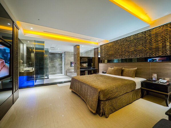 A modern hotel room with a large bed, a TV, a bathroom with a glass shower enclosure, and a zebra-patterned wall. - Wei Feng Motel (Kaohsiung)