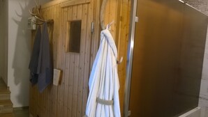Eine Holzsauna mit einer Sitzbank und einem Handtuchhalter.
