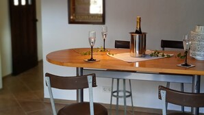 Ein Essbereich mit einem Holztisch, vier Barhocker, einer Chandelier und einer Champagnerflasche.