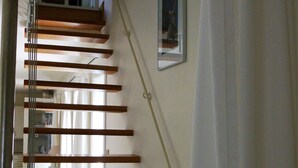Eine Treppe mit Holzbodenstufen und einem Glasgeländer.