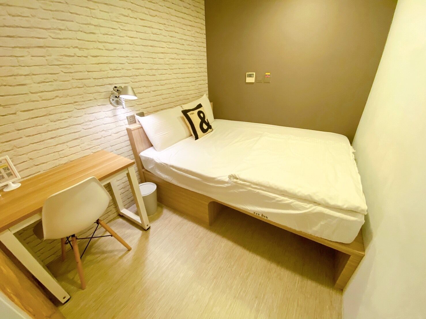 A compact room with a bed, a desk, and a chair.