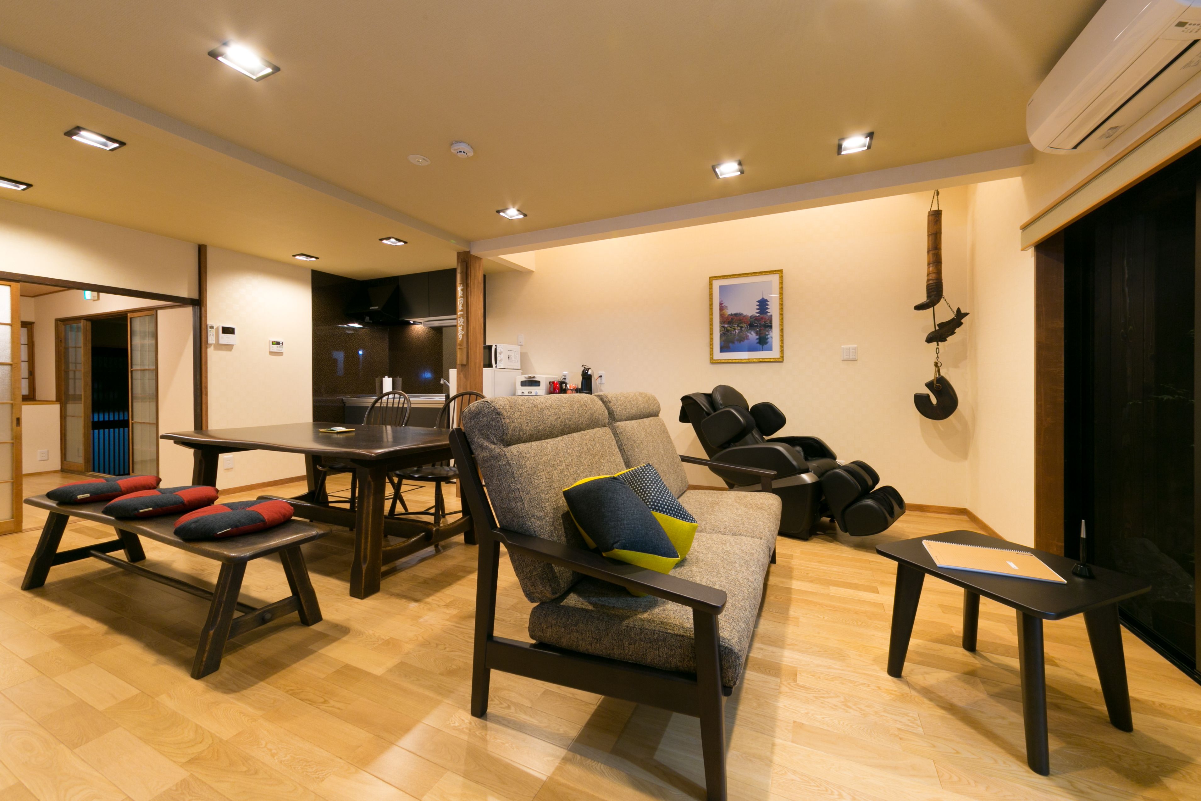 A modern living room with a sofa, a dining table, and a small table with a notebook.