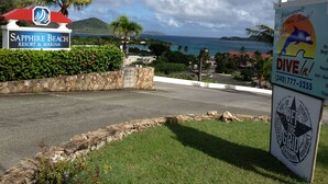 Señal del Sapphire Beach Resort & Marina con vista al océano y montañas al fondo.