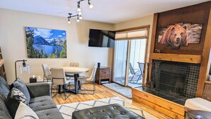 Una sala de estar con chimenea, un sofá, una mesa de comedor y un televisor.