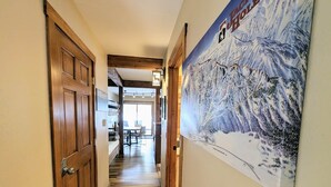 Un pasillo de madera con un cartel de un paisaje montañoso nevado.