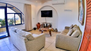 Una sala de estar con dos sofás, una mesa de centro y un televisor montado en una pared en arco.