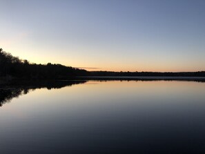 A calm lake at dusk with a clear sky and trees silhouetted against the horizon. - TWO BEATIFUL CABINS  IN THE HEART OF RECREATION: (Spooner)