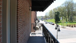 A brick building with a balcony overlooking a street.