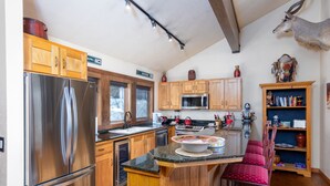 A kitchen with wooden cabinets, stainless steel appliances, and a central island with seating. - New Remodeled interior plus outside updated in Upper DV walk to Silver Lake (DEER VALLEY)