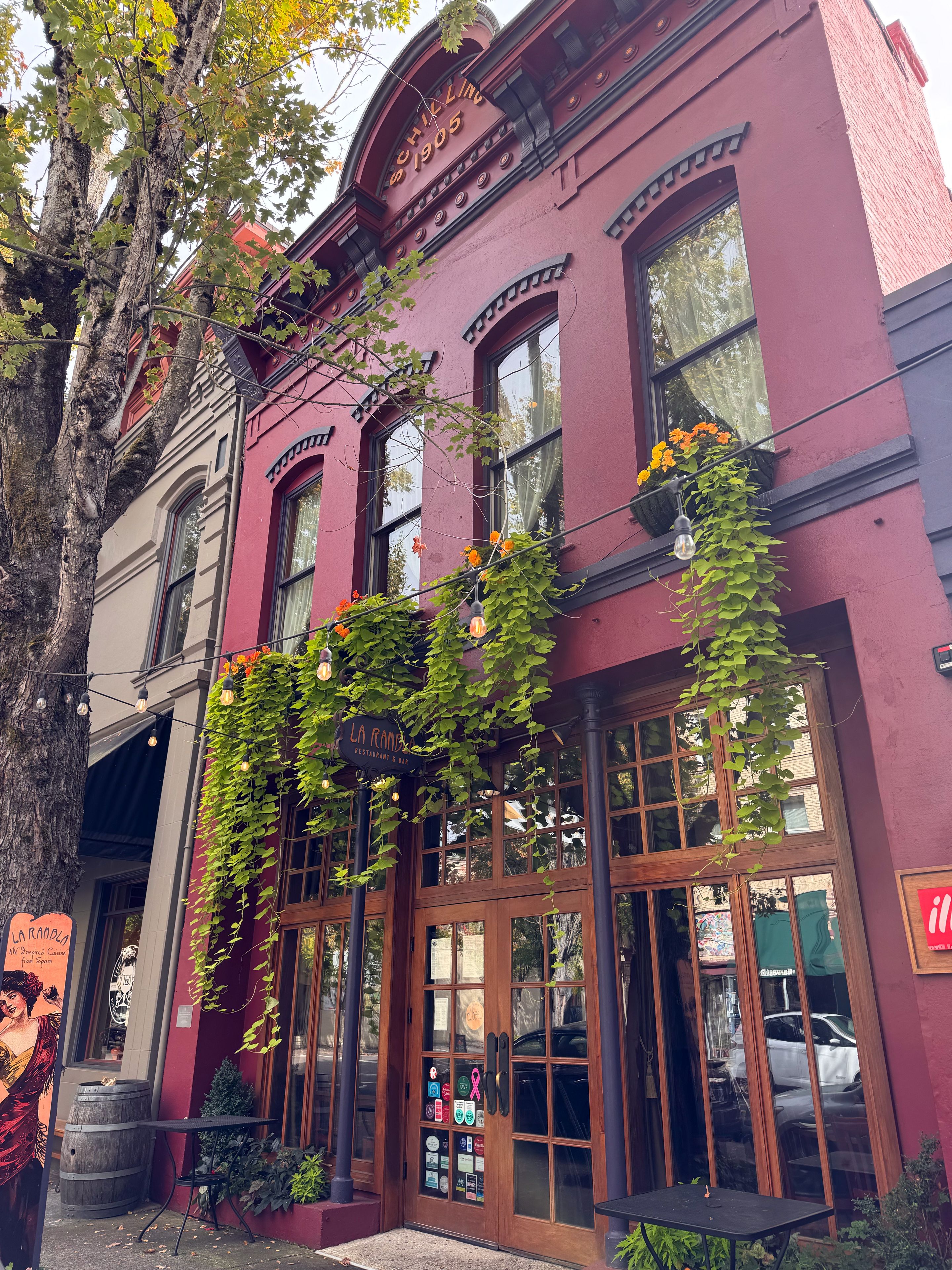 A building with a red facade, large windows, and a sign reading 'La Ramada Restaurant & Bar.'