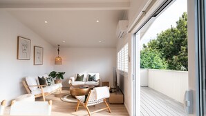 A modern living room with a sofa, chairs, a coffee table, and artwork on the wall. - Stay Mission Bay (Auckland)