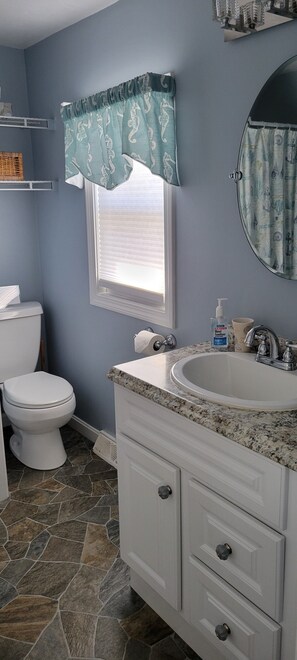 A bathroom with a toilet, sink, and vanity. - Adorable Cottage Walk Across Street to First Beach, Winter min stay 9 mos (Middletown)