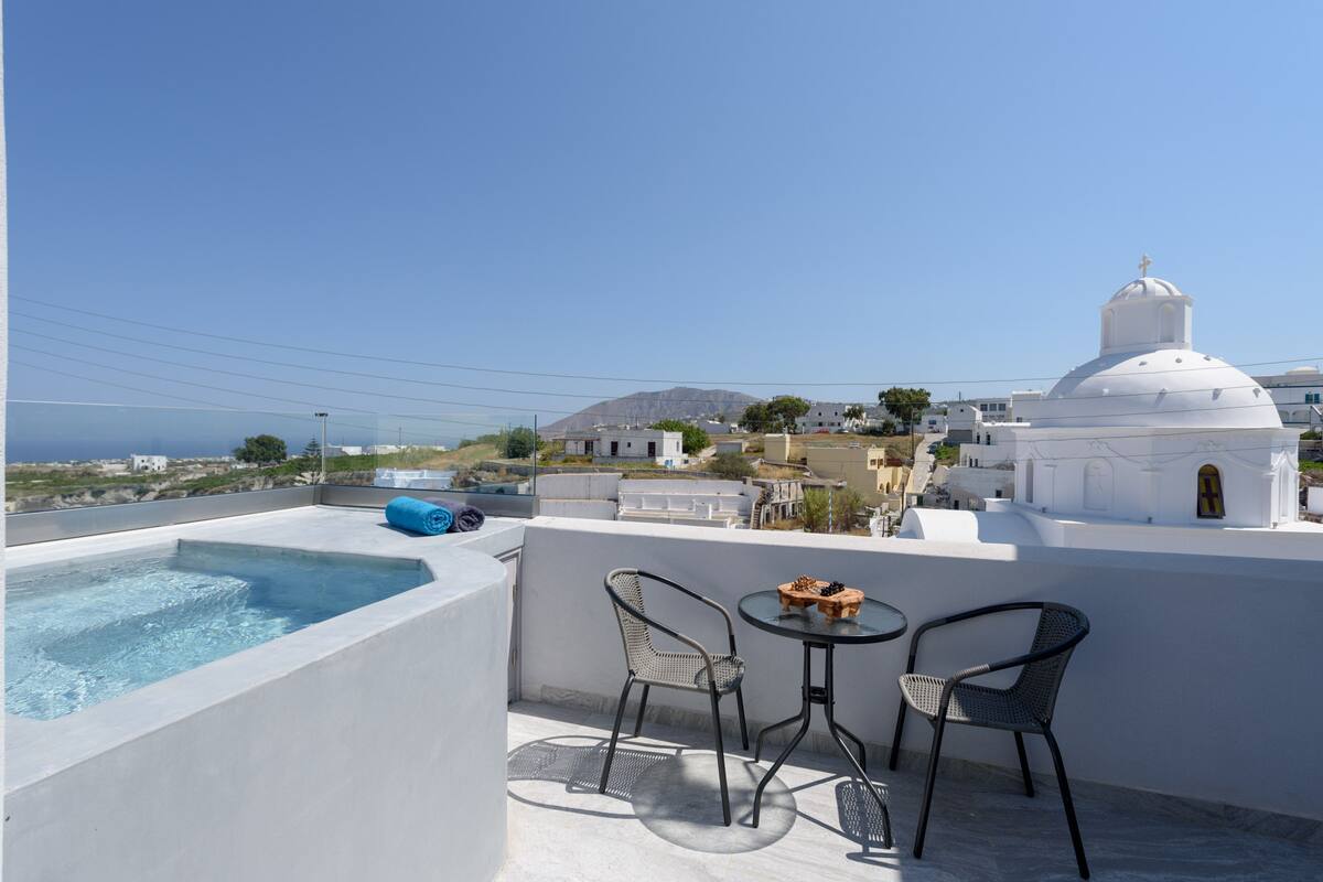 A rooftop terrace with a swimming pool, two chairs, and a table with a snack.