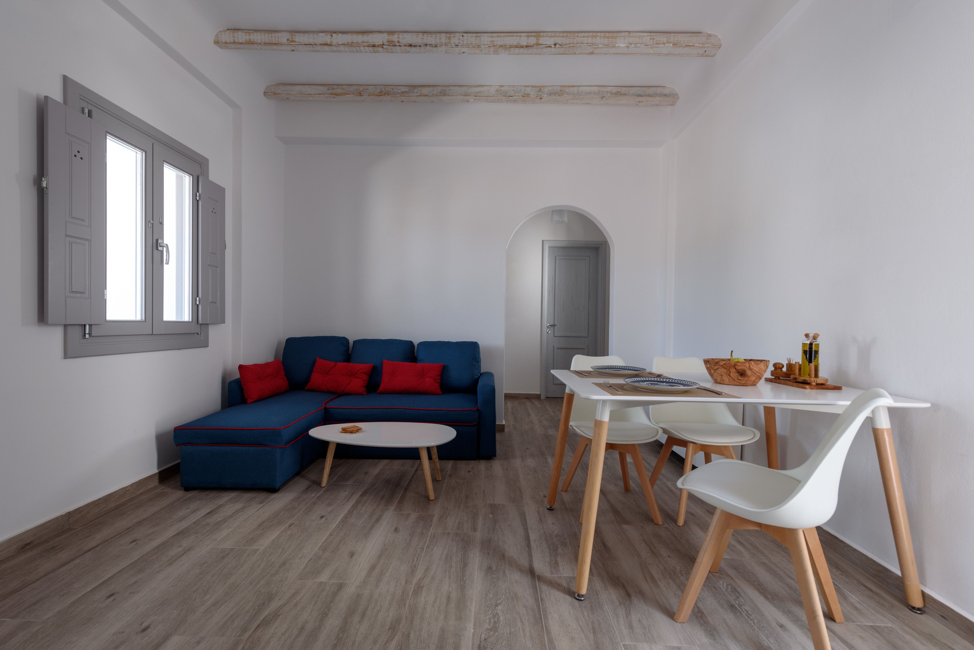 Een moderne woonkamer met een blauwe modulaire bank, een klein wit tafeltje en twee witte stoelen.