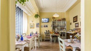 A dining area with a checkered tablecloth, wooden chairs, and a television on the wall. - Live in Chianti (Valencia)