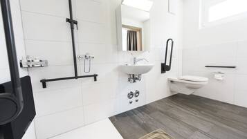 Un baño moderno con ducha, lavabo e inodoro.